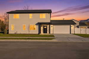 View of front of home featuring concrete driveway, an attached garage, and stone siding