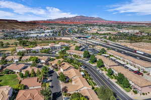 Aerial view of property and surrounding area featuring a mountainous background and nearby suburban area