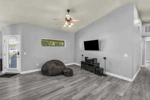 Unfurnished room featuring vaulted ceiling, wood finished floors, and a ceiling fan