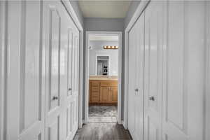 Corridor featuring dark wood-style flooring and a sink