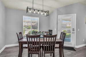 Dining room with light wood-style flooring and vaulted ceiling