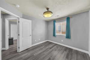Spare room with wood finished floors, a textured ceiling, and a smoke detector