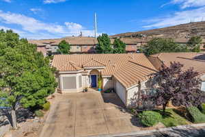 Mediterranean / spanish-style home featuring an attached garage, stucco siding, concrete driveway, a residential view, and a tiled roof