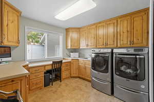 Washroom featuring washer and dryer, cabinet space, a textured ceiling, and light tile patterned flooring