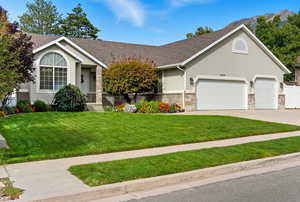 Single story home with a front yard, driveway, stucco siding, an attached garage, and roof with shingles