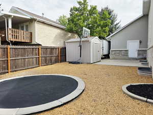 Fenced backyard featuring a shed
