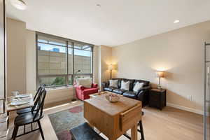 Living room with light wood-style flooring and recessed lighting