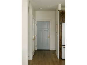 Hall with dark wood-style floors and baseboards