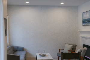Living area with recessed lighting, wallpapered walls, and a fireplace