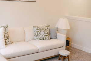 Living area with baseboards and carpet