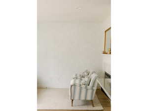 Unfurnished room with a fireplace, wood finished floors, recessed lighting, and wallpapered walls