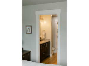 Bedroom with light wood-style floors and ensuite bath