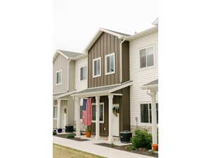 View of front of house with board and batten siding, stone siding, and roof with shingles