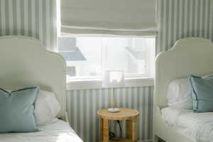 Bedroom featuring wallpapered walls and multiple windows