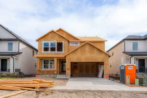 View of front of home with driveway and a garage