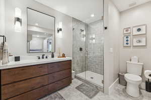 Full bathroom featuring vanity, a stall shower, light tile patterned floors, and recessed lighting
