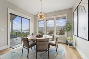 Dining area with a mountain view, a chandelier, and light wood-type flooring