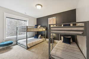 Bedroom featuring light colored carpet and baseboards