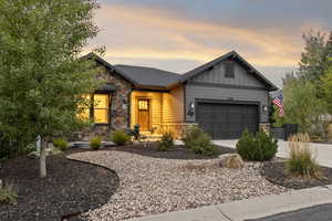 Craftsman-style home with stone siding, concrete driveway, board and batten siding, and an attached garage