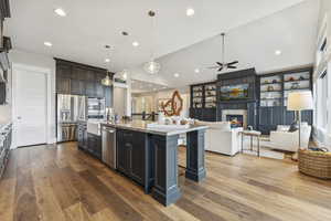 Kitchen with a kitchen bar, light stone counters, recessed lighting, open floor plan, and appliances with stainless steel finishes