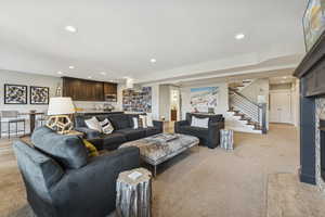 Living area featuring recessed lighting, stairway, and light carpet