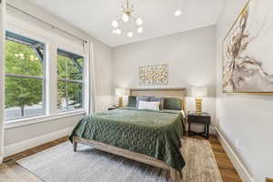 Bedroom with a chandelier, wood finished floors, and recessed lighting
