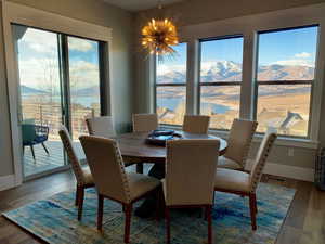 Dining room featuring a water and mountain view, dark wood-style floors, and a chandelier