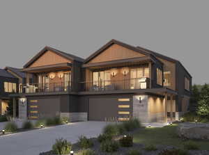 View of front of home with driveway, an attached garage, and a balcony