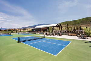 View of tennis court featuring a mountain view, a patio area, and a pergola
