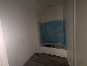 Bathroom featuring a tub and baseboards