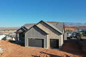 View of property exterior featuring a mountain view, board and batten siding, and a garage