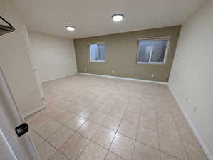 Unfurnished room with light tile patterned floors and baseboards