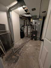 Utilities featuring strapped water heater, water heater, and heating unit