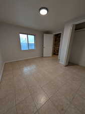 Unfurnished bedroom with a closet and light tile patterned floors