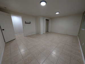 Unfurnished room featuring light tile patterned floors and baseboards