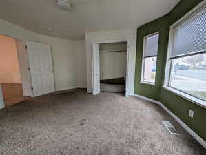 Unfurnished bedroom featuring carpet flooring and a closet