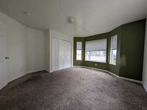 Unfurnished bedroom with carpet, a closet, and a textured ceiling