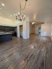 Kitchen featuring open floor plan, recessed lighting, stainless steel appliances, light countertops, and lofted ceiling
