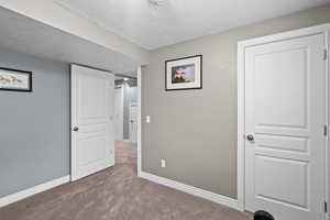 Unfurnished bedroom featuring a textured ceiling and carpet floors