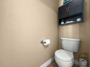 Half bath featuring toilet and tile patterned flooring