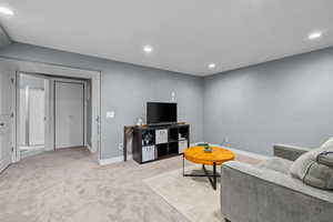 Carpeted living room featuring recessed lighting and baseboards