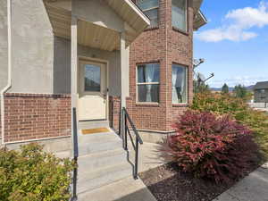 Doorway to property featuring brick siding and stucco siding