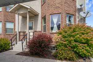 View of exterior entry featuring stucco siding and brick siding