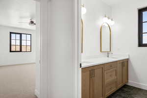 Bathroom with plenty of natural light, double vanity, and dark tile patterned flooring