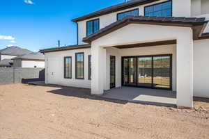 Back of house with a patio area and stucco siding