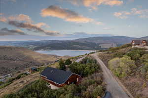 Aerial view of property and surrounding area featuring a water and mountain view