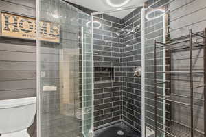 Bathroom featuring toilet and a shower stall