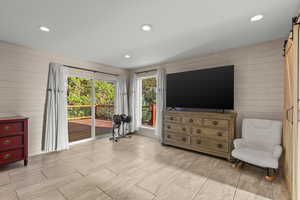 Sitting room with wood walls, a barn door, and recessed lighting