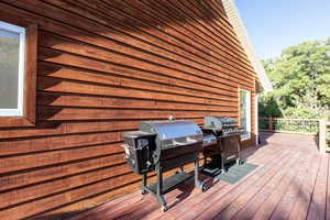 Wooden terrace featuring a grill