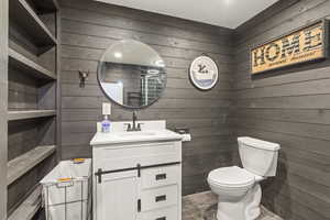 Half bath with wood walls and vanity